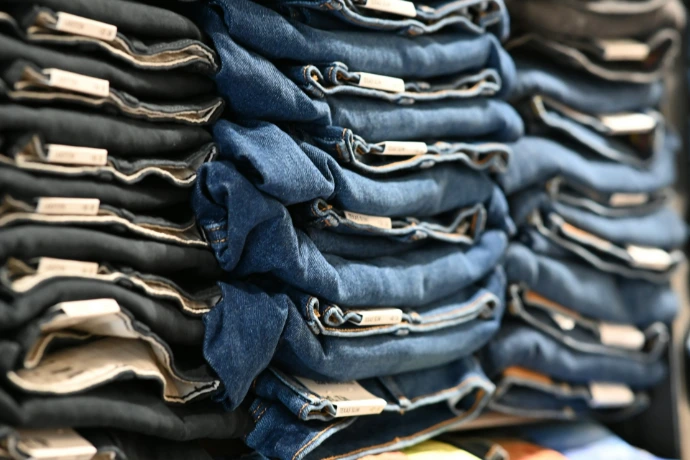 a pile of blue jeans stacked on top of each other